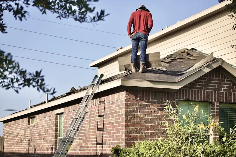 Professional roofer working on a residential roof in Groveton